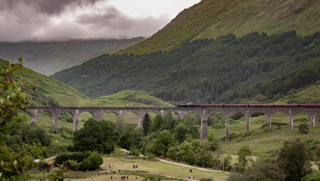 07.18.2021, Scotland, UK: Jacobite steam train passing over Glenfinnan Viaduct near Fort William,...