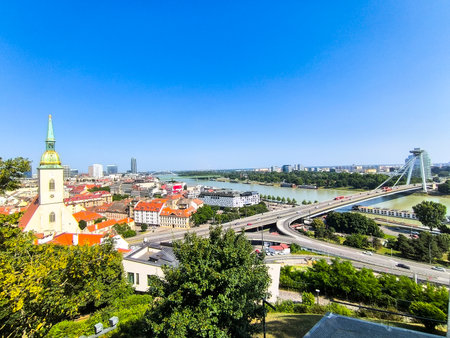 View of Bratislava, Slovakia, from castle hill with St. Martin Cathedral and Most SNP bridge and UFO tower over Danube River on a sunny dayの写真素材