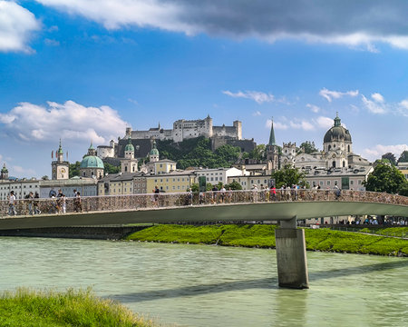 Salzburg, Austria, 06.11.2025: Marko Feingold Steg bridge over Salzach River, with pedestrians walking. Old town, cathedral and castle in backgroundのeditorial素材