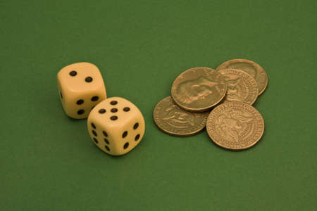 dice and coins on a green rugの写真素材
