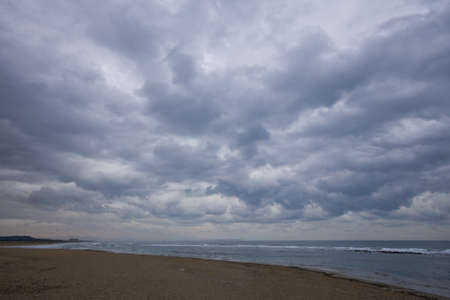 Secluded beach in winter storm threatening skies の写真素材
