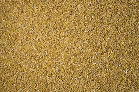 Crushed wheat groats background texture. Healthy food