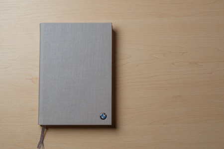 Gray notebook on a brown wooden table background. Top view with copy space