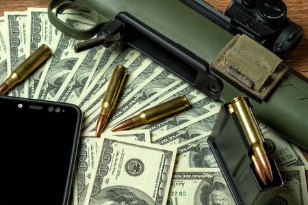 Rifle, magazine and cartridges on money. Concept for crime, contract killing, paid assassin,...