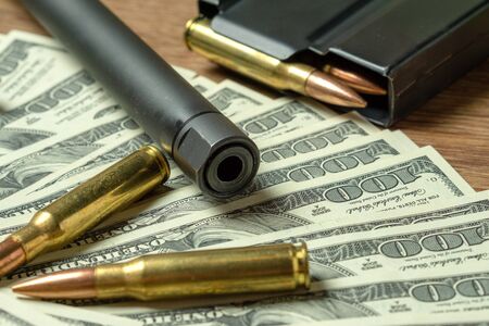 Rifle barrel, magazine and cartridges on dollars. Concept for crime, contract killing, paid...