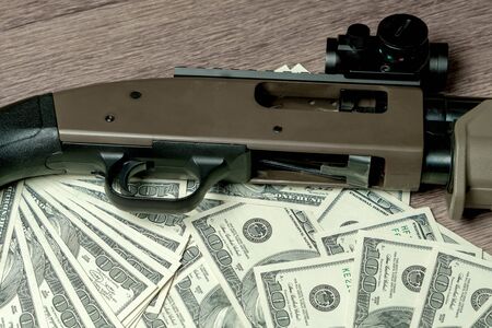 Shotgun on dollars. Concept for crime, global arms trade, weapons sale. Illegal hunting, poachingの写真素材