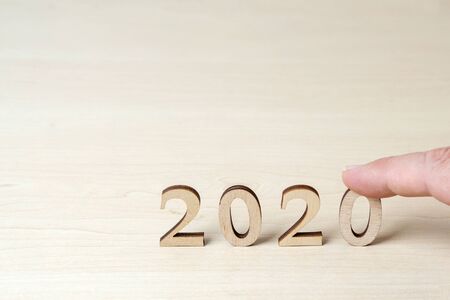 Hand sets wooden numbers on the table, symbolizing 2020 new yearの写真素材