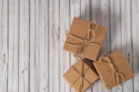 Three cardboard boxes taped on a wooden table. Mail, courier or delivery service concept. Copy...