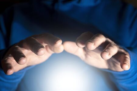 Clairvoyance, foresight, extrasensory perception, and paranormal abilities. Mens hands over white...