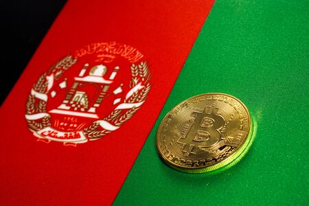 Golden Bitcoin on the flag of Afghanistan. Close-up, copy space.の写真素材