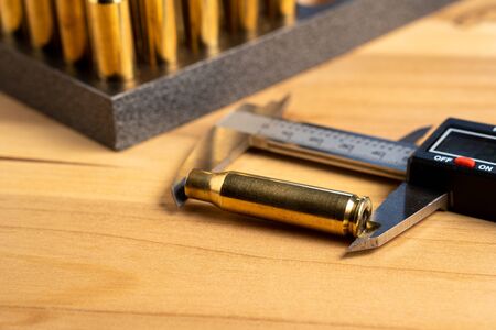 Production of cartridges for a rifle, reload. Measurement of the empty cartridges with a caliper. Close upの写真素材