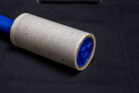 Adhesive roller for cleaning cloth on a black cloth, closeupの写真素材