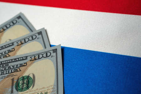 Netherlands national flag and the dollar bills. Business and finance concept, soft focusの写真素材