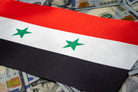 Syria flag with US dollars as background. Concept for investors, soft focus