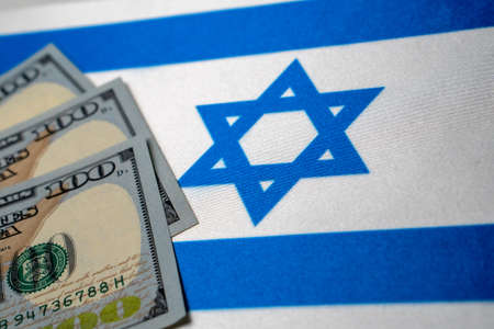 Israel national flag and the dollar bills. Business and finance concept, soft focus