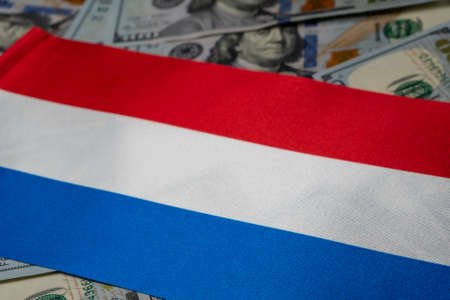 Netherlands flag with US dollars as background. Concept for investors, soft focusの写真素材