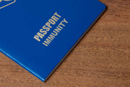 Blue passport with note Immunity on the desk. Travel and conceptの写真素材