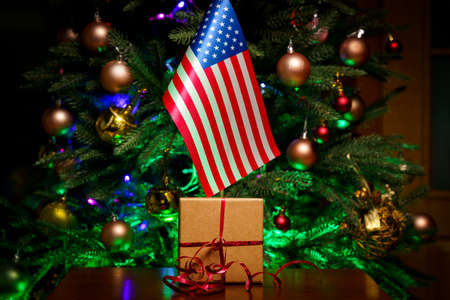 USA flag and gift box on the background of the Christmas treeの写真素材