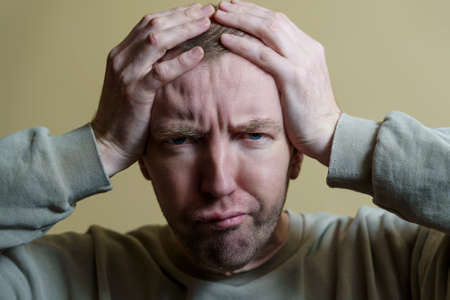 The man put his hands on his head. Portrait of a young man making faces.の写真素材