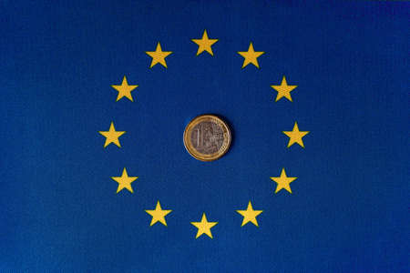 One euro coin in the center of the EU flag.の写真素材