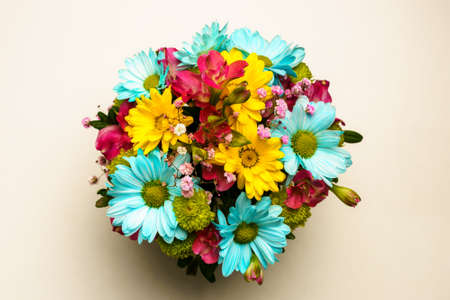 Delicate bouquet of yellow and blue chrysanthemums on a white table, top view.