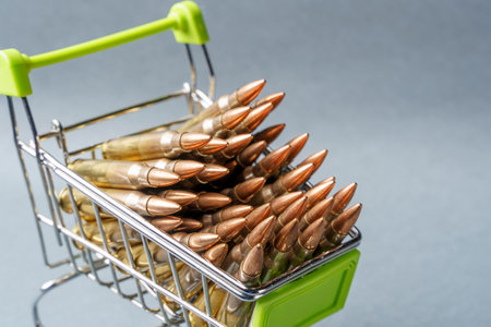 Rifle cartridges in a shopping cart. 223 caliber ammo cartridges and a small shopping basket. Macroshotの写真素材