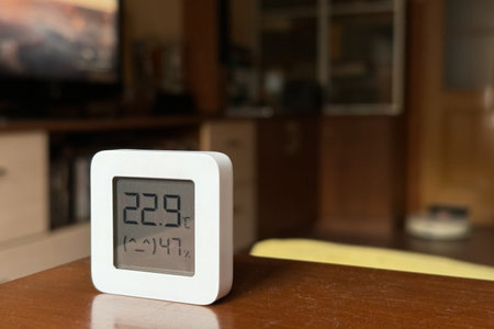 Comfortable humidity and temperature in the apartment. White hygrometer on the table.の写真素材