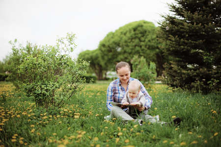 Happy mother and her  baby sitting at the parkの写真素材