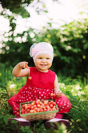 Young girl holding cherries in the basket の写真素材