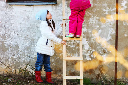 Children help each other to climb the ladder.の写真素材
