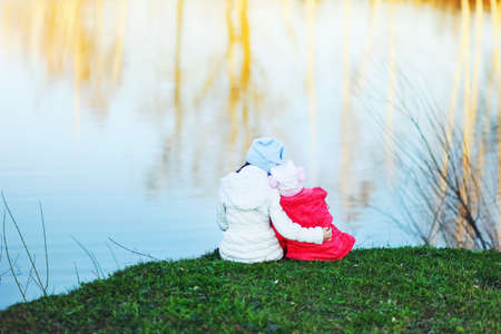 The children happy outdoors sitting on river.の写真素材