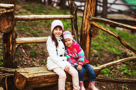 The children happy outdoors sitting on park.の写真素材