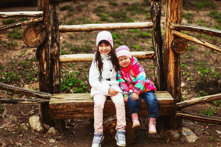 The children happy outdoors sitting on park.の写真素材