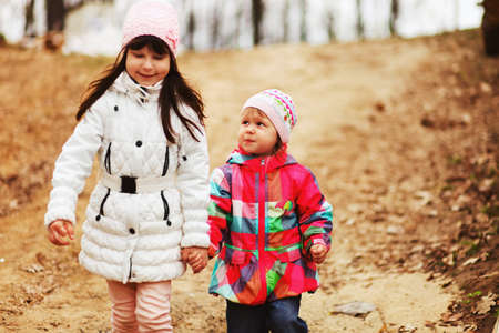 The children happy outdoors sitting on park.の写真素材