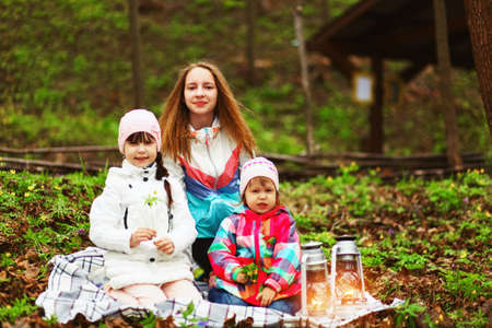 The children happy outdoors sitting on park.の写真素材