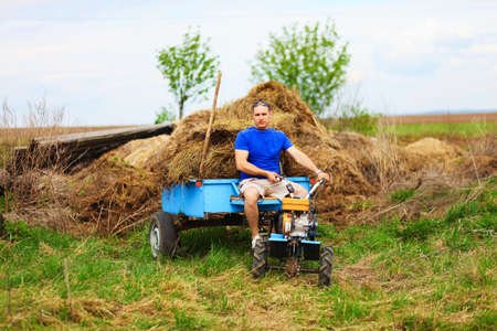 The man carries hay on a cart.の写真素材