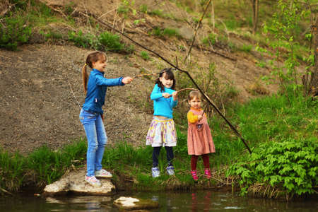 The children happy outdoors sitting on river.の写真素材