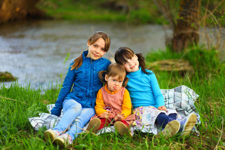 The children happy outdoors sitting on river.の写真素材