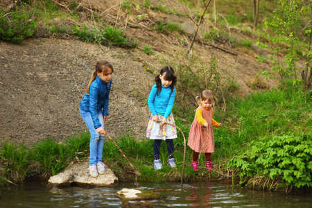 The children happy outdoors sitting on river.の写真素材