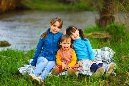 The children happy outdoors sitting on river.の写真素材