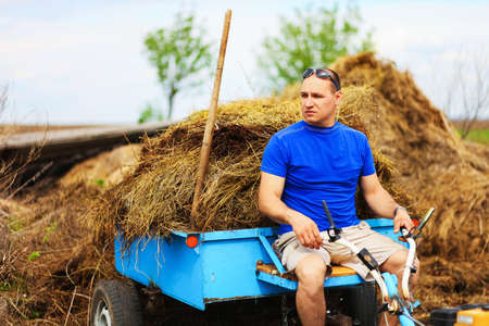 The man carries hay on a cart.の写真素材