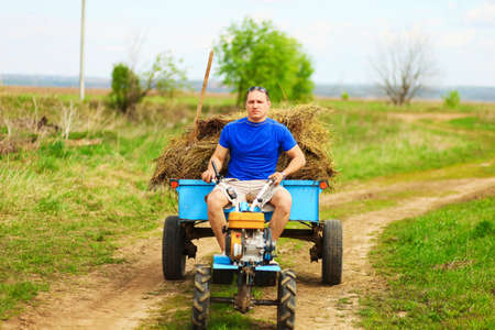 The man carries hay on a cart.の写真素材