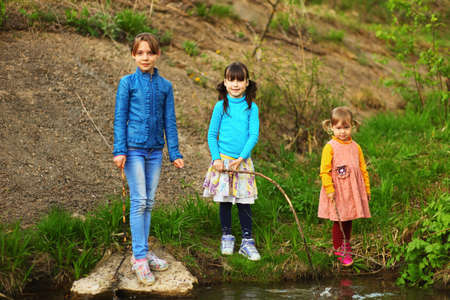 The children happy outdoors sitting on river.の写真素材