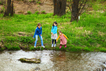 The children happy outdoors sitting on river.の写真素材