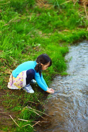 The children happy outdoors sitting on river.の写真素材