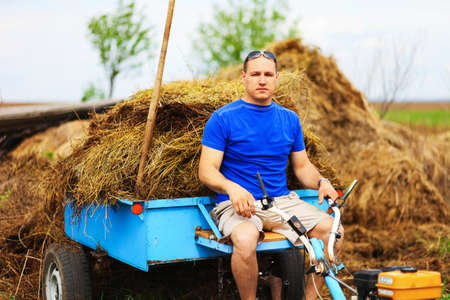 The man carries hay on a cart.の写真素材