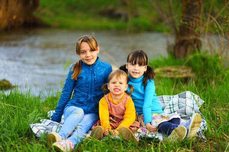The children happy outdoors sitting on river.の写真素材