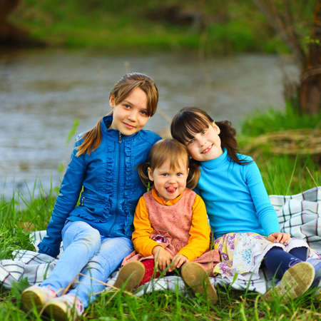 The children happy outdoors sitting on river.の写真素材
