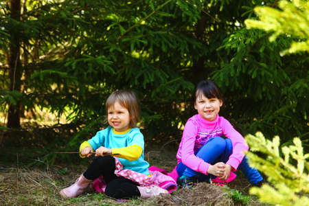 The children happy outdoors sitting on park.の写真素材