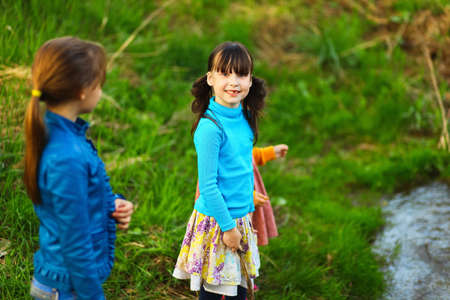 The children happy outdoors sitting on river.の写真素材